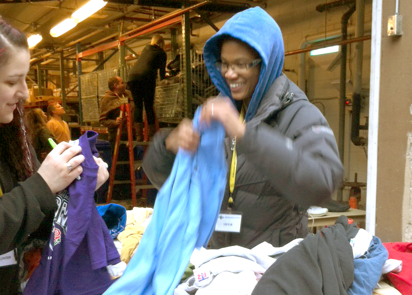 Volunteers help sort clothing to be given away to homeless guests
